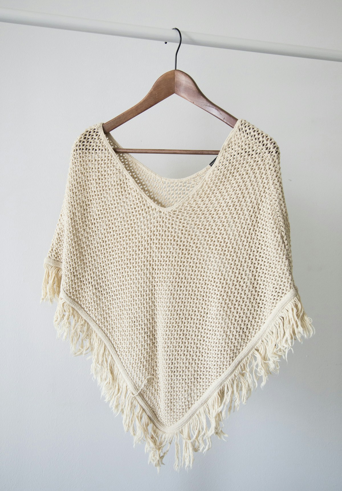 Cream open-knit garment on a wooden hanger